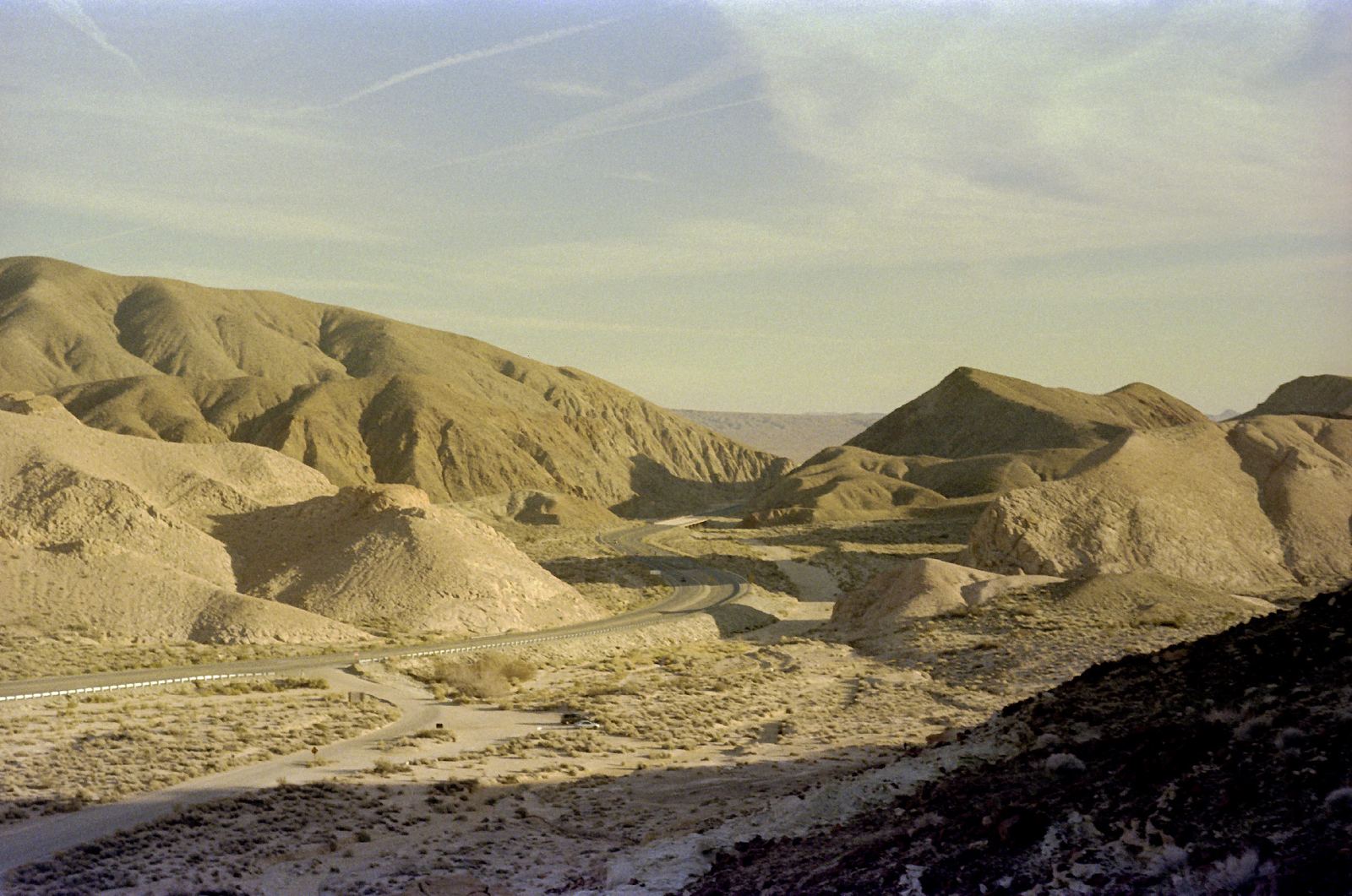 Desert hills in low gold light with dark ridgelines behind.