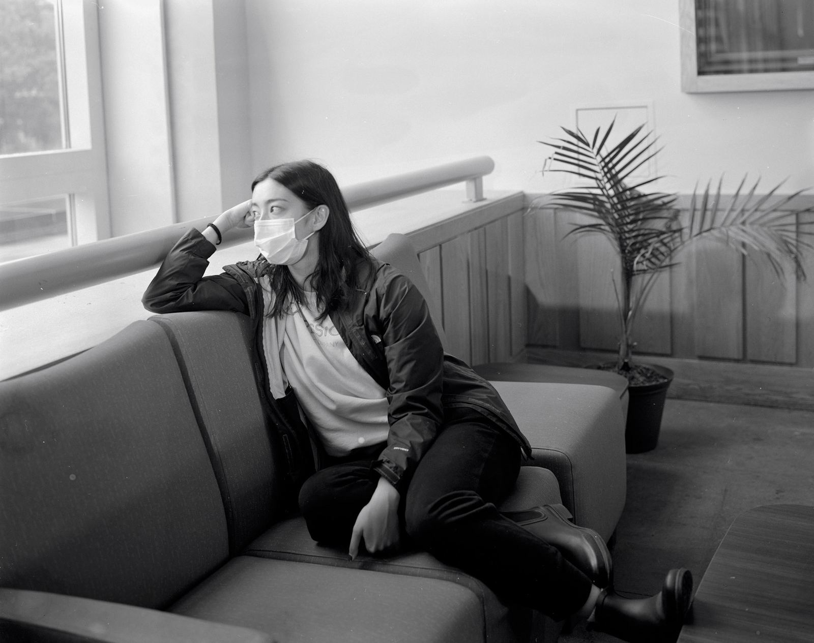 Woman reclining on a sofa in black and white, arm behind her head.
